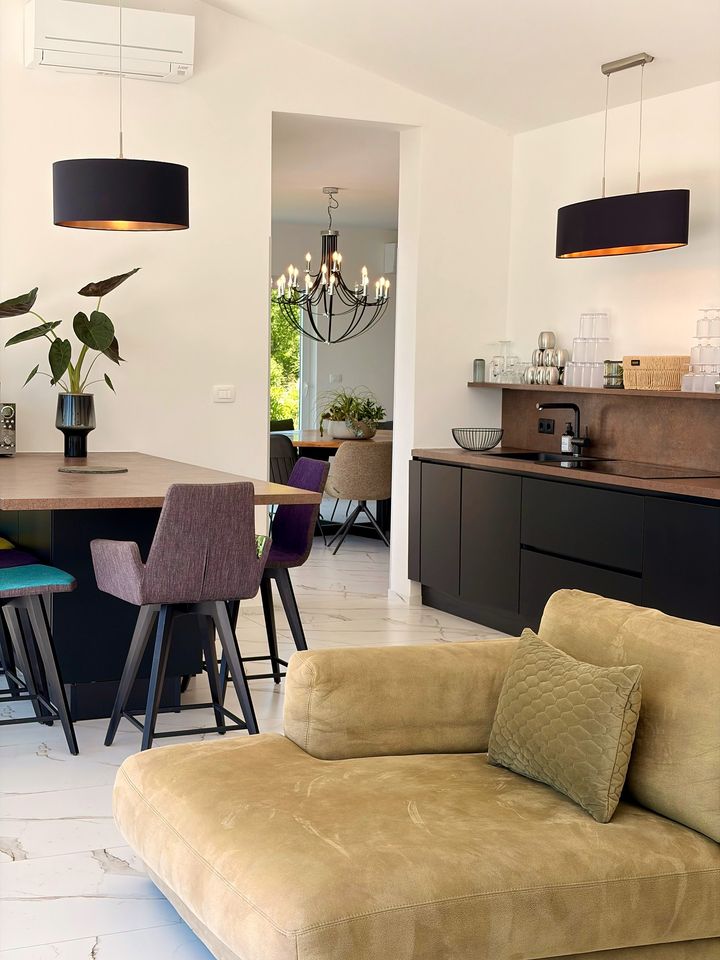living and kitchen with chandelier and velvet sofa