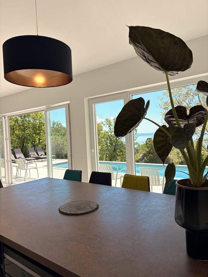 dining table framing pool and Adriatic beyond