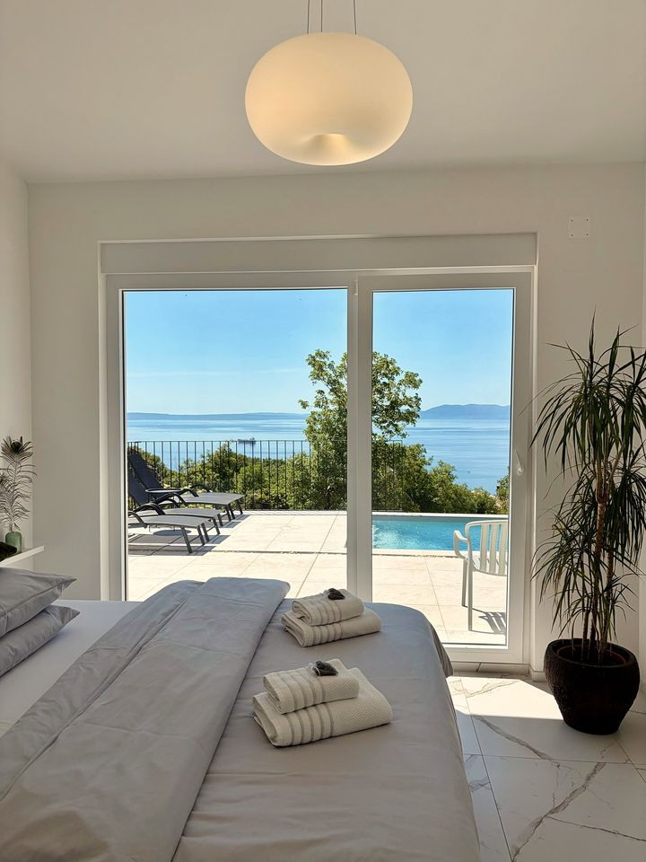 bright bedroom opens to pool and sea