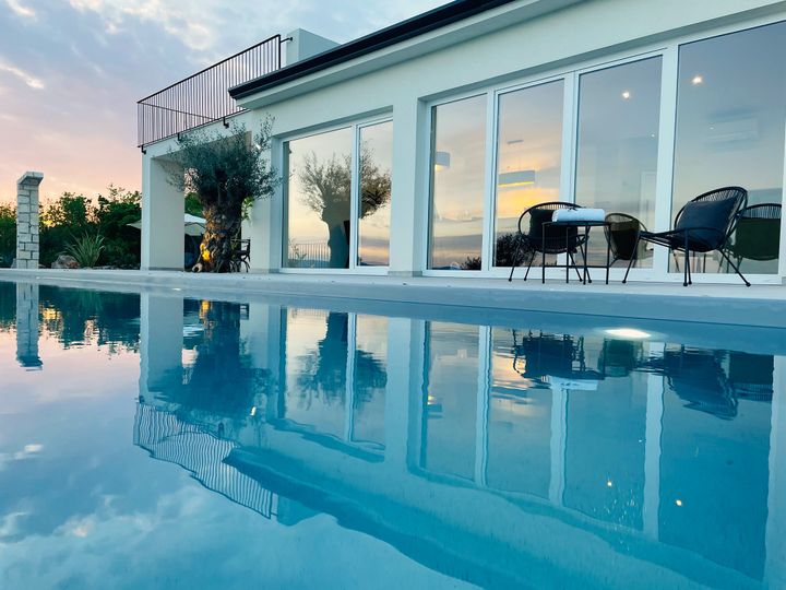 villa reflected in pool at blue-hour dusk