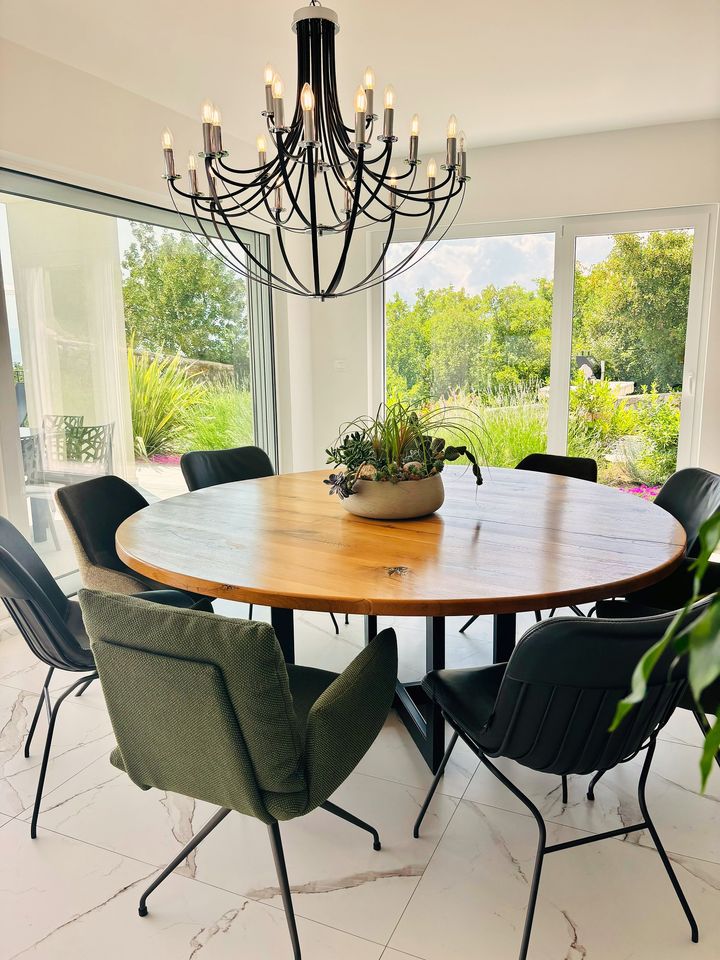 round table under chandelier, lush garden view