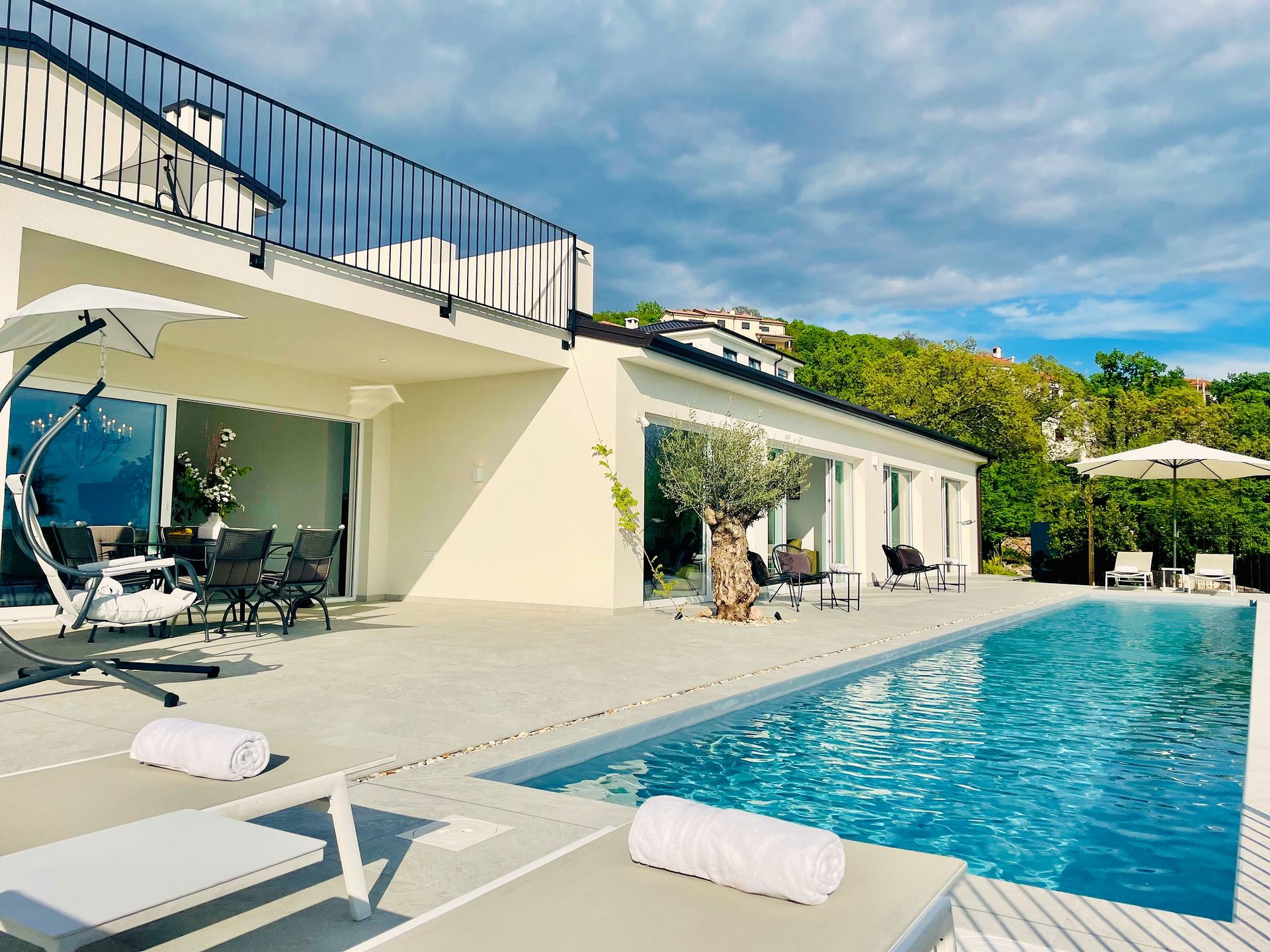 villa facade and pool beneath dramatic sky