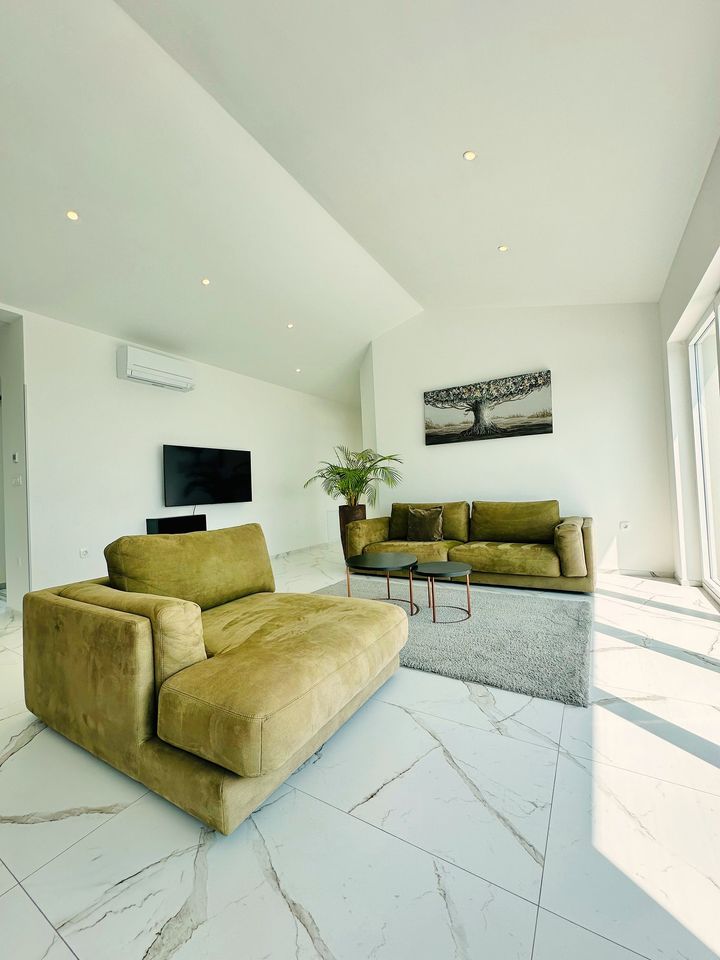 bright lounge, olive sofas, marble, tree artwork