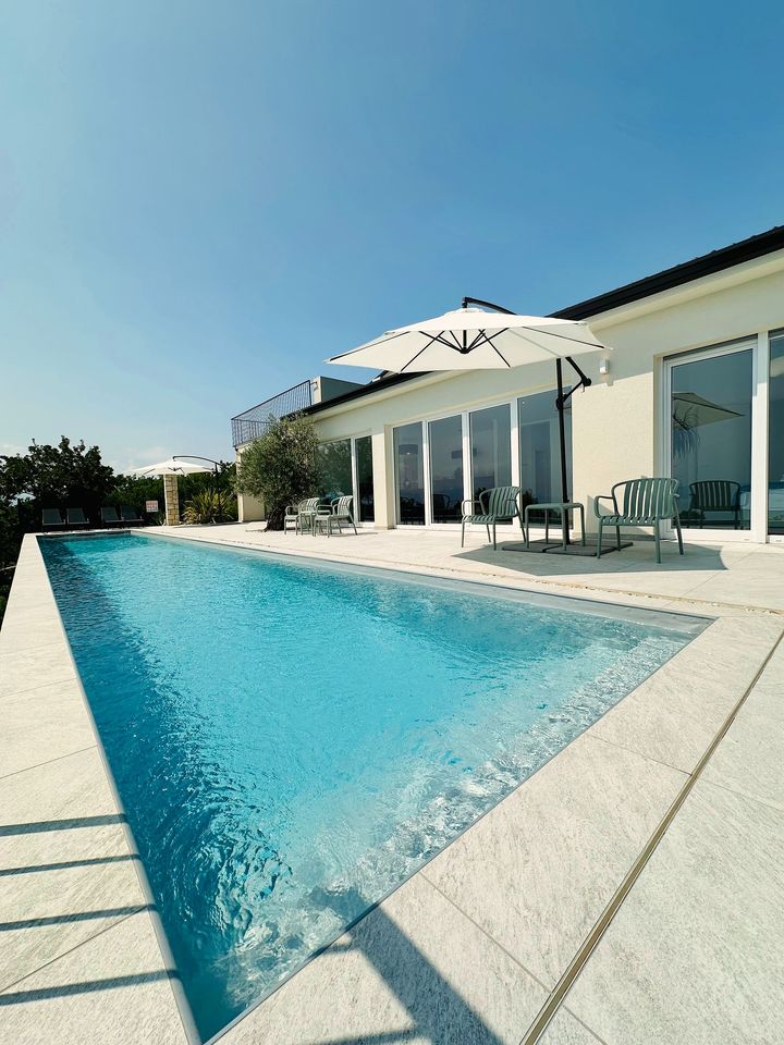 turquoise infinity pool beside villa in sunshine