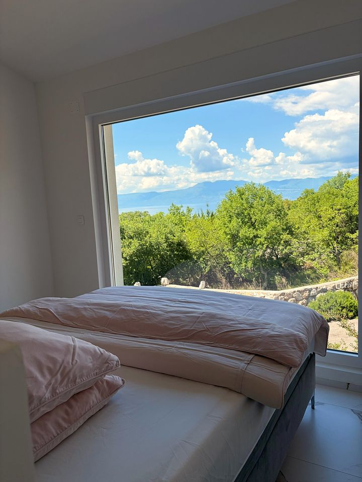 blush bed framing sea and mountain panorama